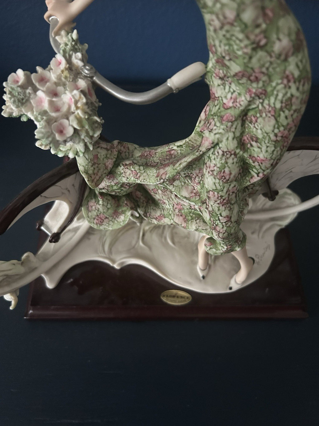 This figurine is a Giuseppe Armani sculpture titled "The Bicycle - Spring"