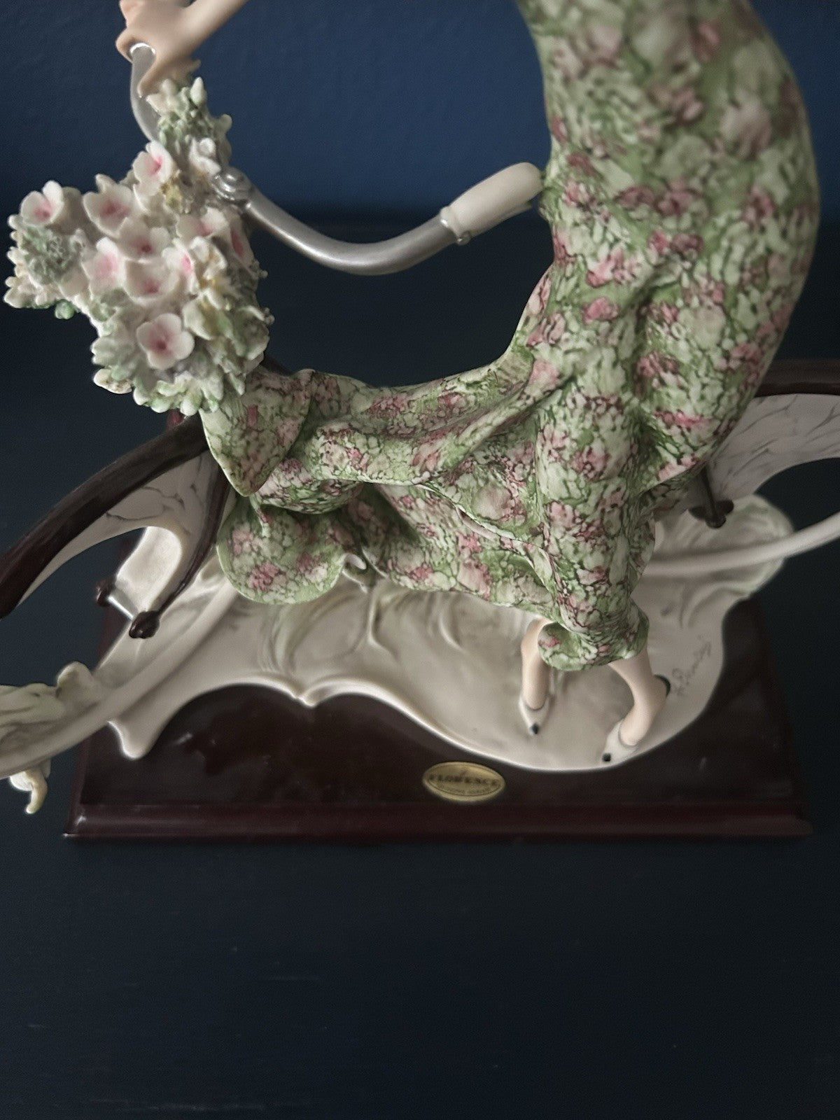 This figurine is a Giuseppe Armani sculpture titled "The Bicycle - Spring"